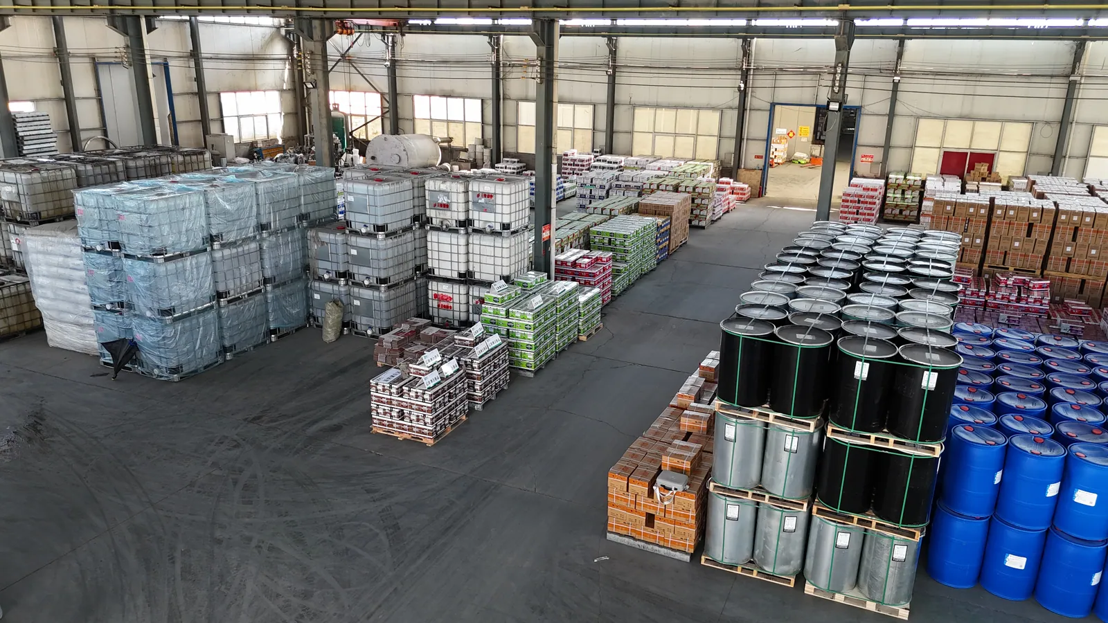 Factory storage area with material containers, drums and finished-goods cartons